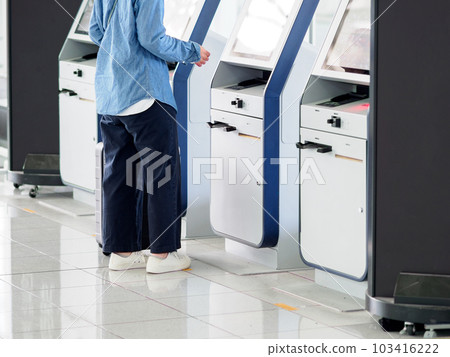 在機場航站樓操作自助值機機的婦女 在機場航站樓操作自助值機機的婦女 103416222