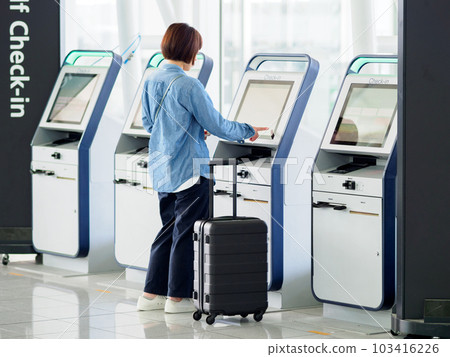 在機場航站樓操作自助值機機的婦女 103416226