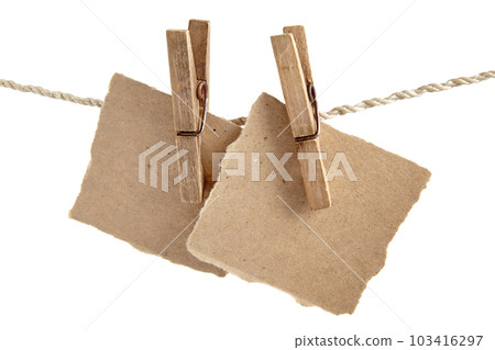 Craft note paper pinned with an old wooden clothespin on a rope on a white background 103416297