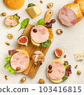 Mix of different snacks and appetizers. Space for text. Deli, sandwiches, olives, sausage, fig, cheese, Gorgonzola, walnut, Salad leaves on light stone backgrounds. Top view. 103416815