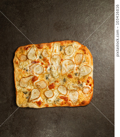 Pizza with pear, Gorgonzola cheese and parmesan cheese on gray stone. Mini pizza with pear slice cut out. Top view 103416816