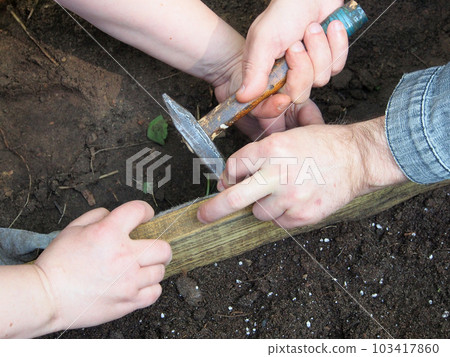 Planting plants, close-up of hands with a tool, gardeners are building a garden bed. Planting plants, close-up of hands with a tool, gardeners are building a garden bed. 103417860