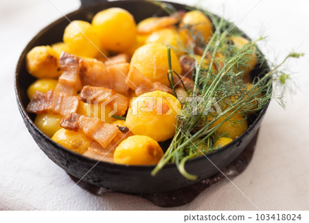 appetizing freshly cooked fried new potatoes with bacon served in a frying pan appetizing freshly cooked fried new potatoes with bacon served in a frying pan 103418024