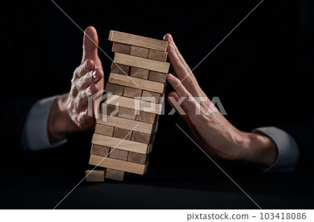Plan and strategy in business, Risk To Make Business Growth Concept With Wooden Blocks, hand of man has piling up and stacking a wooden block. 103418086