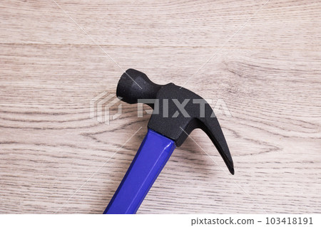 Blue hammer on a wooden background closeup 103418191