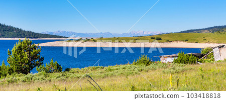 Beautiful lake and mountains view with old wooden house 103418818