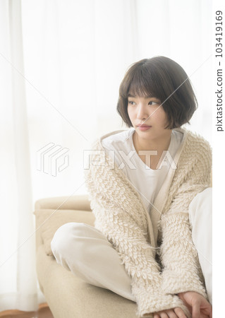 Young woman relaxing on the sofa (black mist filter) 103419169