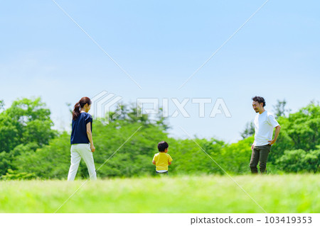 Three-person family playing in the park Three-person family playing in the park 103419353