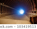 Light in end of tunnel. Long underground concrete corridor in abandoned bunker, toned. Tunnel in underground protective bunker. Protection against nuclear attack 103419513