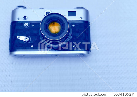 Old vintage film photo camera with lens isolated on pale blue 103419527