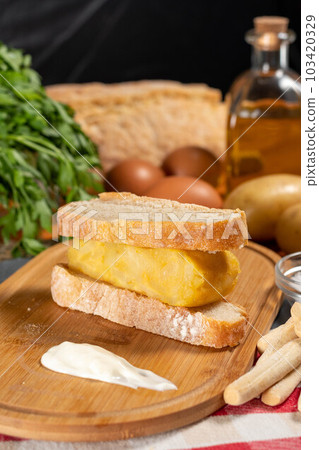 Spanish omelette with potatoes and onion, typical Spanish cuisine. Tortilla espanola. Rustic dark background 103420329
