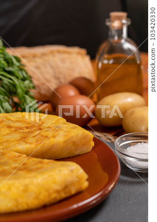 Spanish omelette with potatoes and onion, typical Spanish cuisine. Tortilla espanola. Rustic dark background 103420330
