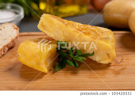 Spanish omelette with potatoes and onion, typical Spanish cuisine. Tortilla espanola. Rustic dark background 103420331