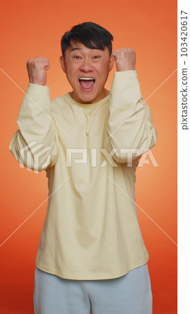 Asian chinese happy man celebrating success, winning, birthday, lottery jackpot goal achievemen Asian chinese happy man celebrating success, winning, birthday, lottery jackpot goal achievemen 103420617