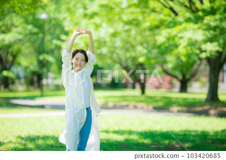 A woman stretching in a fresh green park A woman stretching in a fresh green park 103420685