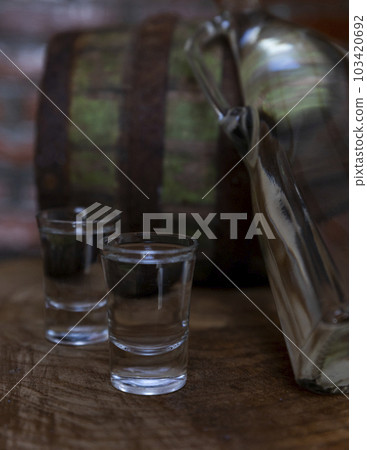 Hard alcoholic drink or brandy from fermented fruits, old wooden table, still life 103420692
