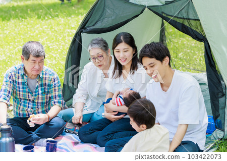 Three generation family enjoying camping 103422073