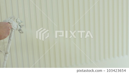 Close up of man painter paints the walls with paint spray gun. Airless spray painting. Close up of man painter paints the walls with paint spray gun. Airless spray painting. 103423654