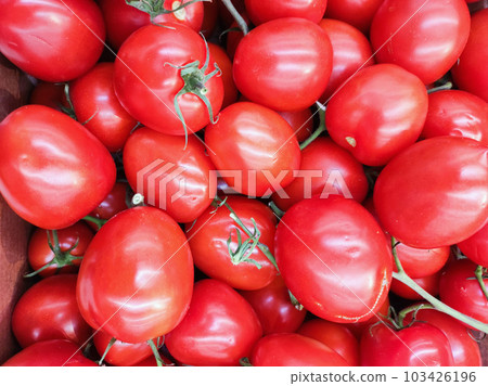 Background of beautiful red tomatoes. A counter at a farmer's market. Background of beautiful red tomatoes. A counter at a farmer's market. 103426196