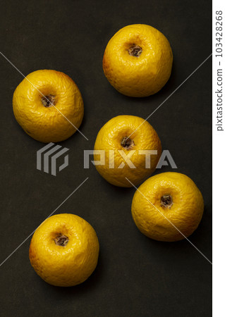 Five yellow aging apples on a dark background, top view Five yellow aging apples on a dark background, top view 103428268