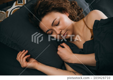 Relaxing sleep of young woman in cozy bed for calm morning 103428710