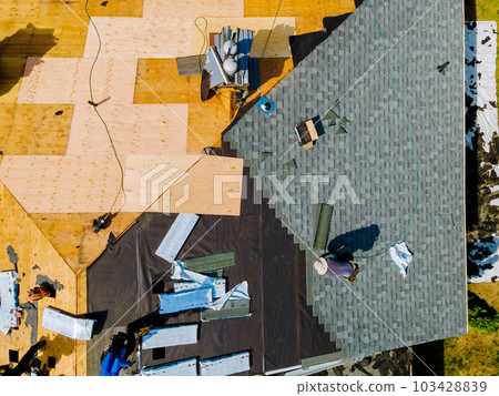 Roof repairs were carried out on apartment building, involving replacement of old roof with new shingles Roof repairs were carried out on apartment building, involving replacement of old roof with new shingles 103428839