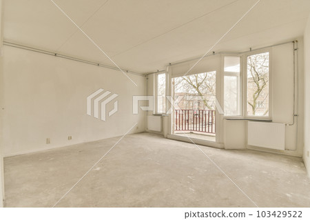 an empty room with white walls and no one person standing in the corner looking out at the view from the window an empty room with white walls and no one person standing in the corner looking out at the view from the window 103429522