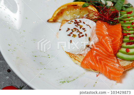 Summer healthy fastfood lunch, breakfast with Pancake with red fish, avocado and egg for breakfast. Aesthetic still life, healthy food concept Summer healthy fastfood lunch, breakfast with Pancake with red fish, avocado and egg for breakfast. Aesthetic still life, healthy food concept 103429873