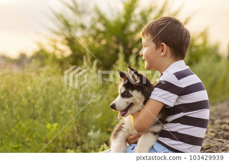 The boy with his favorite four-legged friend. Puppy in the hands of a child The boy with his favorite four-legged friend. Puppy in the hands of a child 103429939