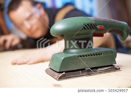 The carpenter man checks the quality of the wooden surface The carpenter man checks the quality of the wooden surface 103429957