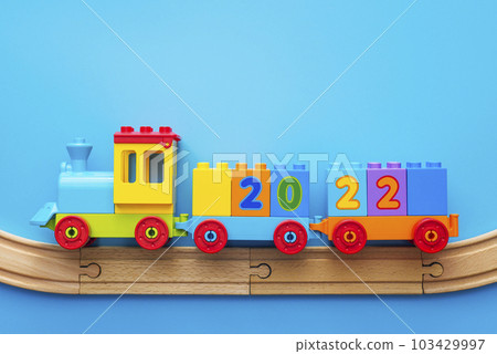 Happy New year 2022. Christmas toy locomotive with numbers 2022 on a blue 103429997