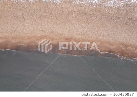 Winter in cold Baltic sea snowy beach in Gdansk. Aerial view of snow covered beach and dunes and dark calm sea nature landscape captured with drone. Tourism in Poland Winter in cold Baltic sea snowy beach in Gdansk. Aerial view of snow covered beach and dunes and dark calm sea nature landscape captured with drone. Tourism in Poland 103430057