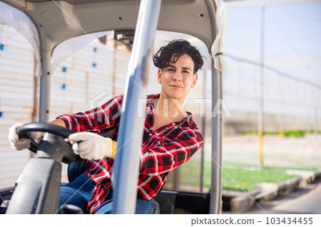 Concentrated woman working on forklift in greenhouse Concentrated woman working on forklift in greenhouse 103434455