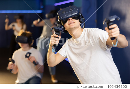 Friends using virtual reality headset and controlling joysticks Friends using virtual reality headset and controlling joysticks 103434500