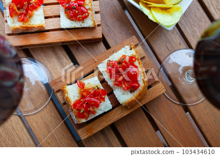 Italian bruschetta with tomato and chips served with wine Italian bruschetta with tomato and chips served with wine 103434610