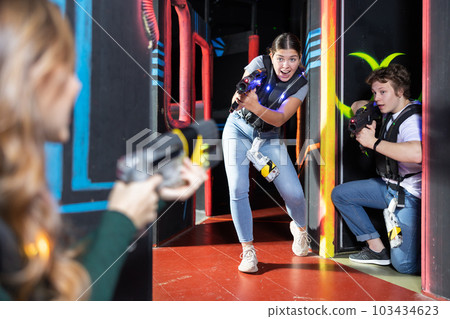 Girl running and dodging while playing lasertag 103434623