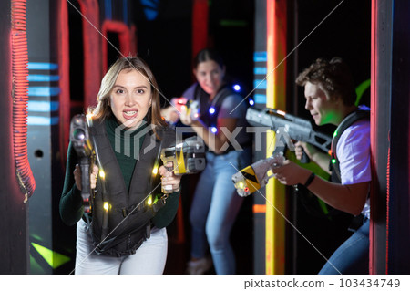 Young woman playing lasertag in arena Young woman playing lasertag in arena 103434749