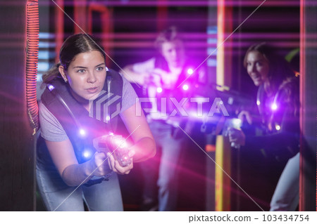 Girl running and dodging while playing lasertag Girl running and dodging while playing lasertag 103434754