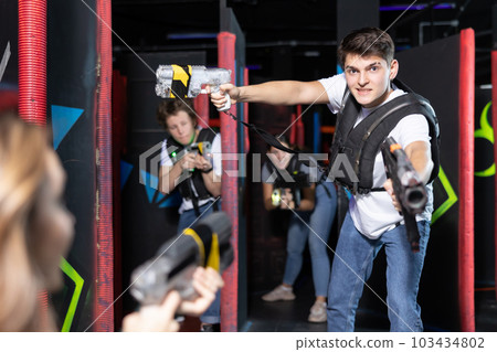 Boy running and dodging while playing lasertag 103434802