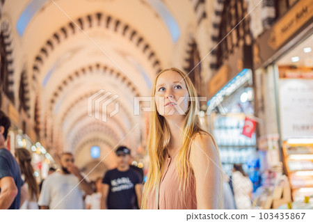 A tourist woman walks among the countless shops at the Grand Bazaar and Egyptian Bazaar in Istanbul. Shopping and travel in Turkey concept. Istanbul historical Egyptian Bazaar. Misir Carsisi, spice 103435867