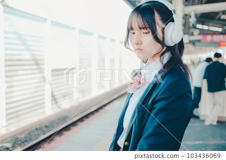 High school girl listening to music with headphones 103436069