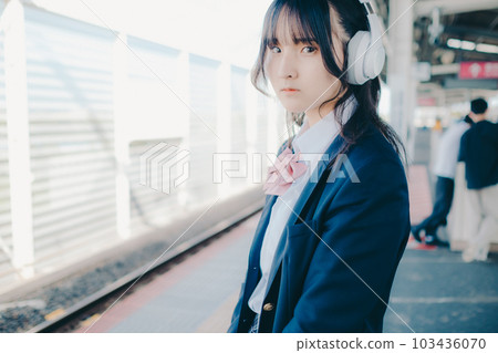 High school girl listening to music with headphones 103436070