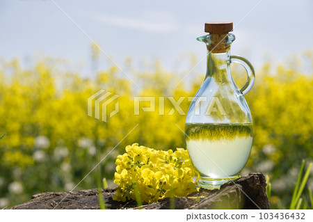 Oil decanter with reflections of yellow rape field Oil decanter with reflections of yellow rape field 103436432