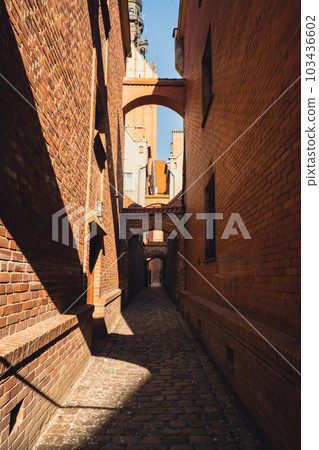 Elblag, Poland. Medieval alleyway in Old Town of Elblag city in Poland. Narrow cobblestone passage between tenement houses called The Church Path. View of City of Architecture famous popular tourist 103436602