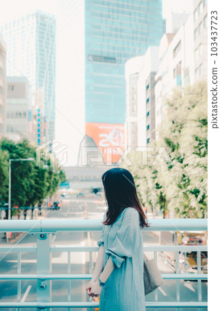 A woman holding a smartphone in the city A woman holding a smartphone in the city 103437723