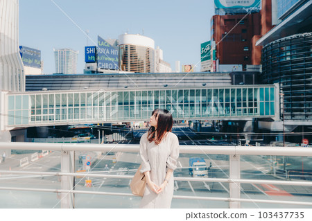 A woman holding a smartphone in the city A woman holding a smartphone in the city 103437735