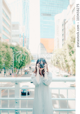 A woman holding a film camera 103438275