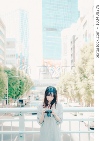 A woman holding a film camera 103438278