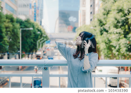 Woman wearing headphones on an overpass 103438390