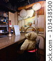 teddy bear sitting on bar counter 103438500
